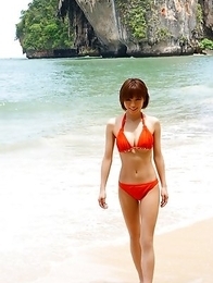 Japanese Yumiko Shaku  in orange bath suit takes a walk on the beach